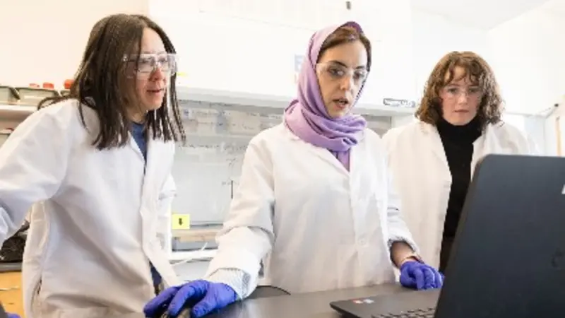 Doctoral students Khadijeh Khederlou, left, and Noel Lefevre, right, are working with College of Engineering faculty member Elain Fu on the development of a device to measure levels of anti-seizure medicine in the body via saliva. Photo by Karl Maasdam.