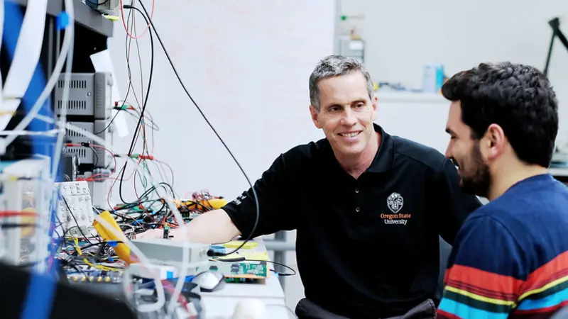 Tom Weller with a student in a lab