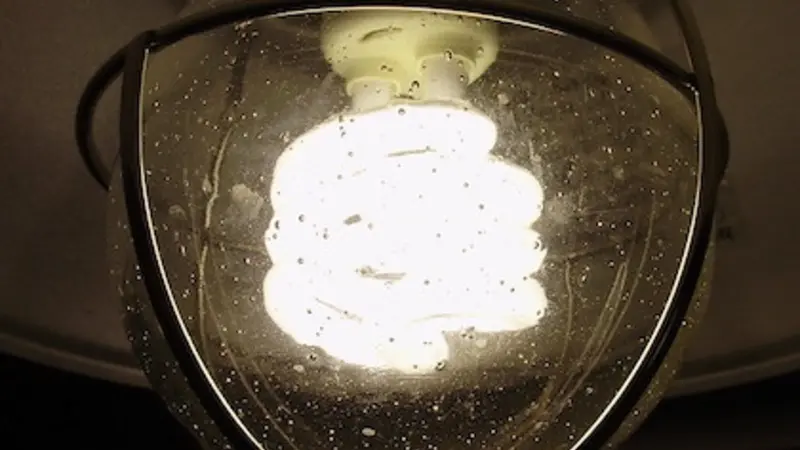 Stock image of a brightly lit light bulb inside a clear glass fixture