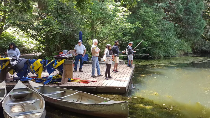 Kids fishing on a dock on a pond.