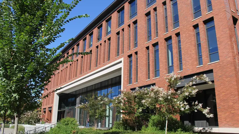Image of Austin Hall facade with trees blooming