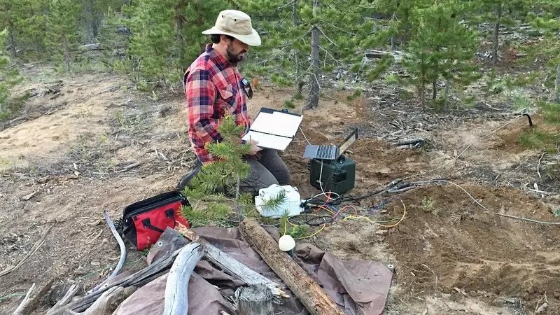 A researcher configures instrumentation at Newberry Crater. 