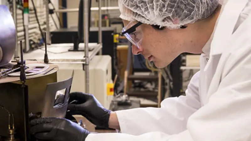 Carson Rivard, a doctoral student in electrical and computer engineering, is using a thermal evaporator in the Oregon State University cleanroom to deposit a thin film of aluminum. The cleanroom serves as a teaching laboratory as well as a research facili