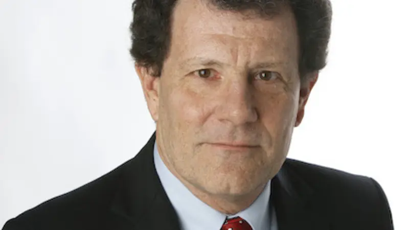 Image shows a headshot of Nicholas Kristof, 63-year-old white man with dark brown hair, wearing a black suit jacket, light blue button-down shirt and red tie.