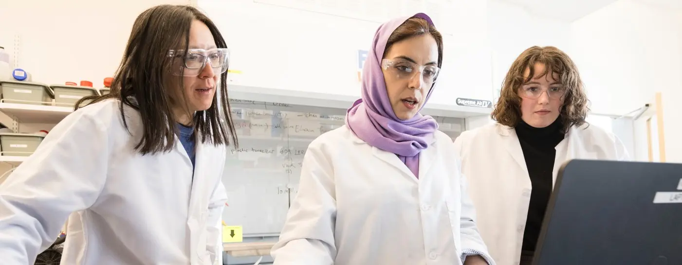 Doctoral students Khadijeh Khederlou, left, and Noel Lefevre, right, are working with College of Engineering faculty member Elain Fu on the development of a device to measure levels of anti-seizure medicine in the body via saliva. Photo by Karl Maasdam.
