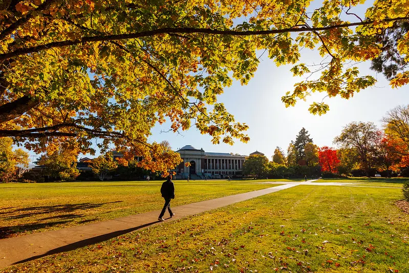 Person walking on a sidewalk on the quad in front of the Memorial Union at Oregon State University.