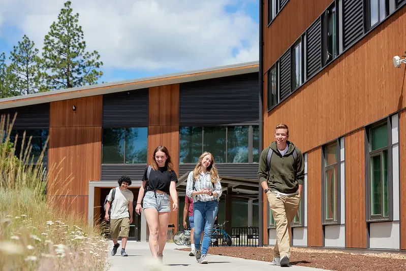 Students walk on the sidewalk outside a building at OSU-Cascades. 