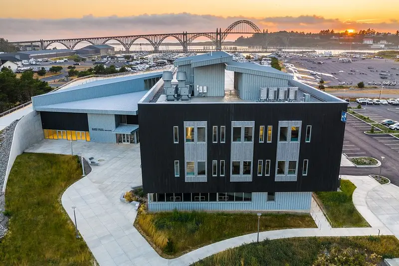 Image of an aerial view of the Gladys Valley Marine Studies Building with the Yaquina Bay Bridge in the background. 
