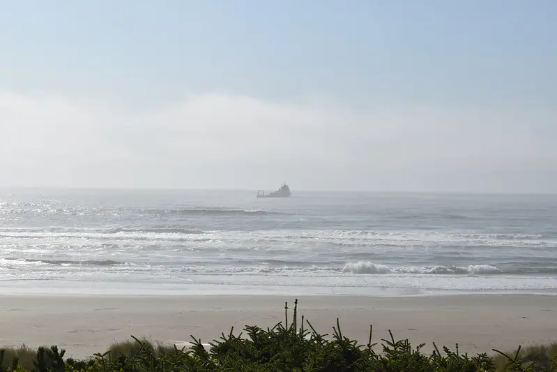 A vessel is seen in the ocean from land at Driftwood Beach. 