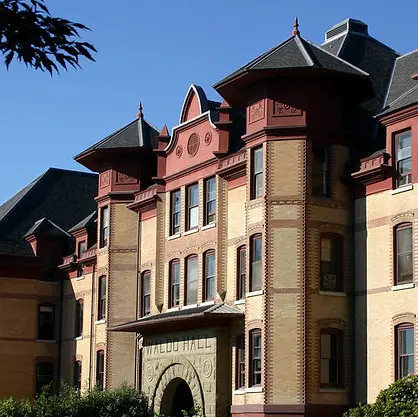 Stock image of Waldo Hall; building is old-fashioned yellow brick with red at the top and black roofs on the spires.