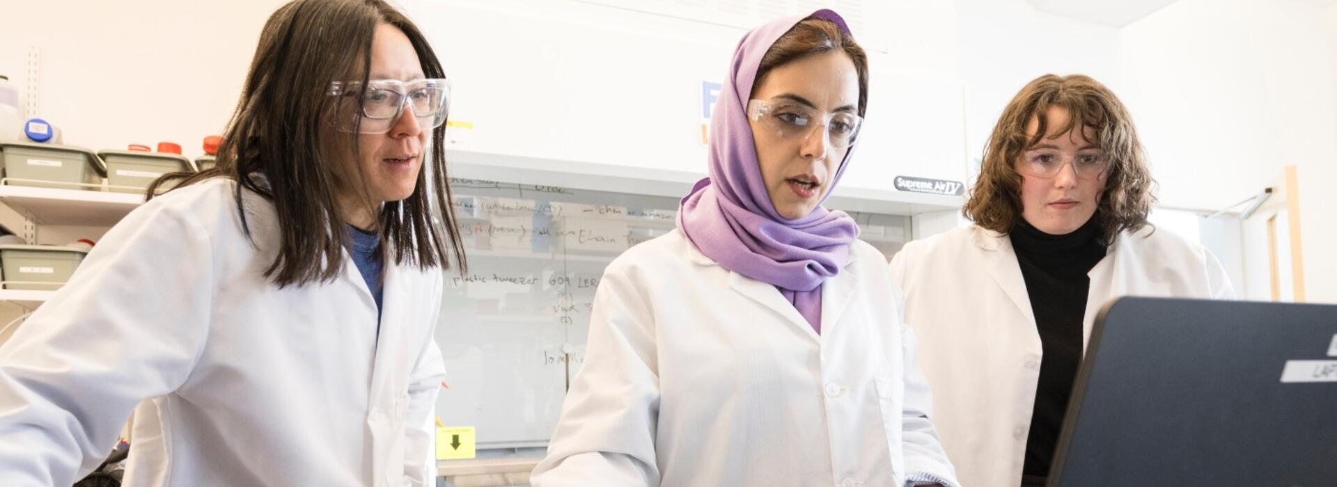 Doctoral students Khadijeh Khederlou, left, and Noel Lefevre, right, are working with College of Engineering faculty member Elain Fu on the development of a device to measure levels of anti-seizure medicine in the body via saliva. Photo by Karl Maasdam.