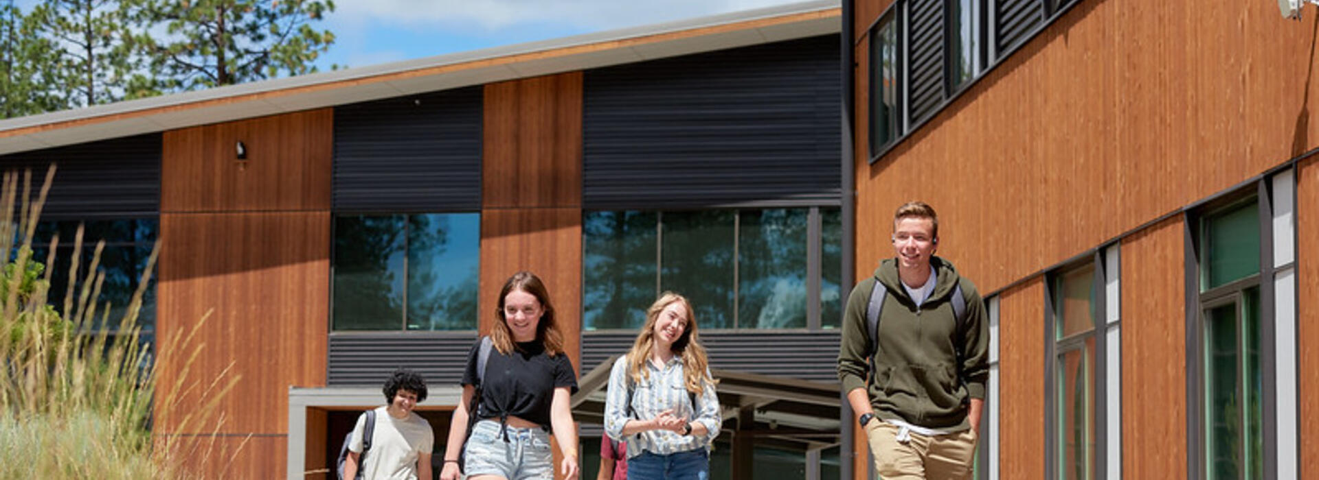 Students walk on the sidewalk outside a building at OSU-Cascades. 