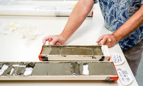 Close up of person examining sediment core on a table