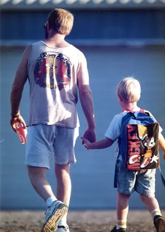 Dad and young son walking hand in hand